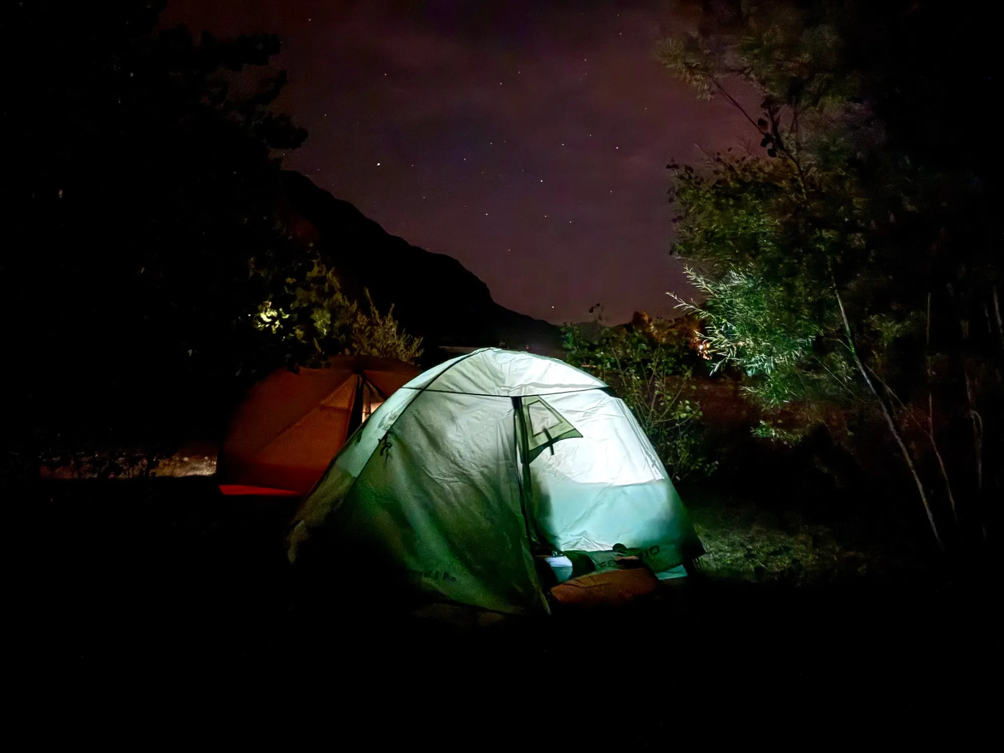 Campement packraft sous un ciel étoilé en montagne